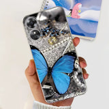 a woman holding a phone case with a blue butterfly on it