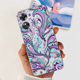 a woman holding a phone case with a purple paisley pattern