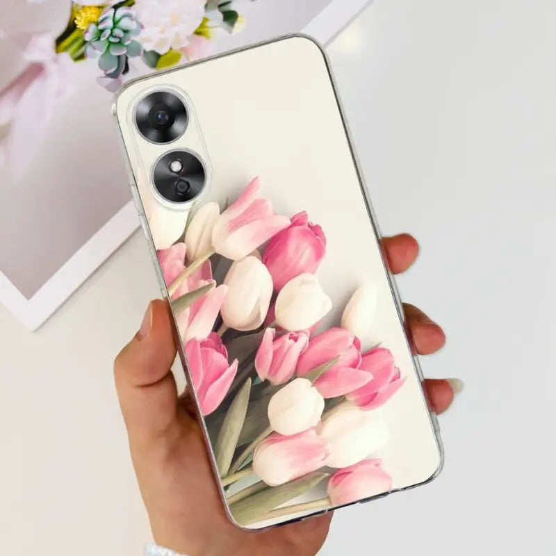 a woman holding a phone case with pink tulips
