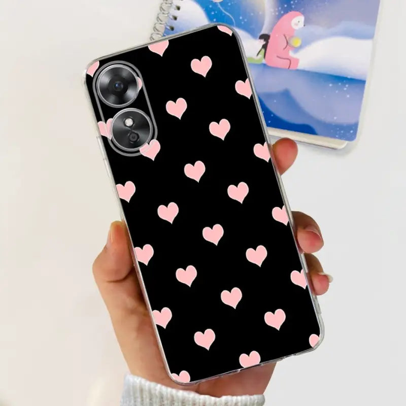 a woman holding a phone case with pink hearts on it