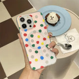 a person holding a phone case with a colorful polka dot pattern