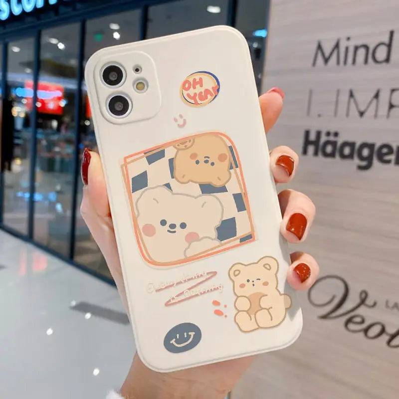 a woman holding a phone case with a cartoon bear