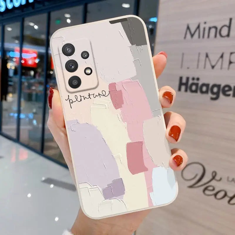 a woman holding a phone case with a painting on it