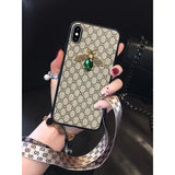a woman holding a phone case with a green bee on it