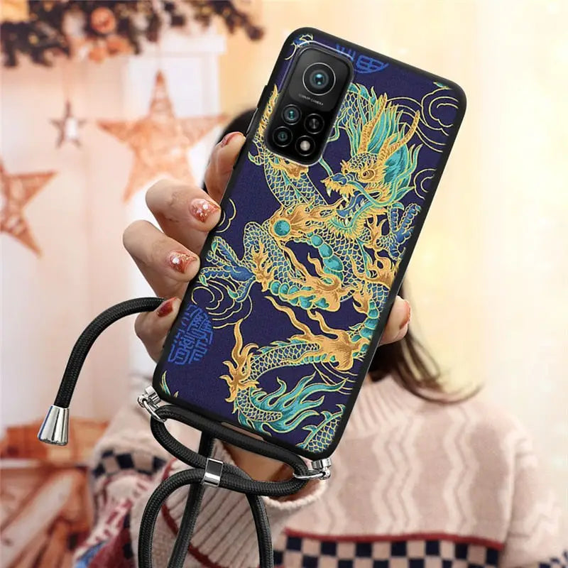 a woman holding a phone case with a dragon design