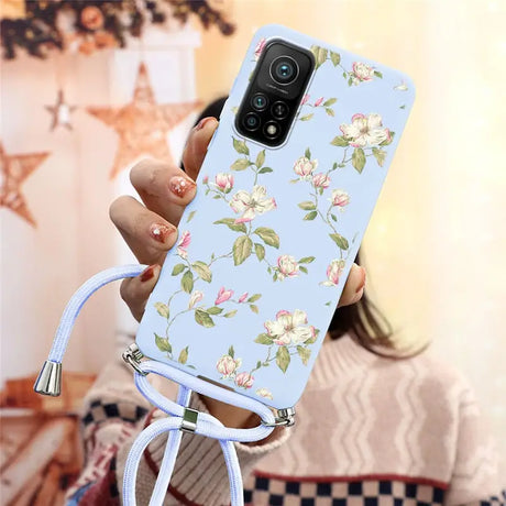 a woman holding a phone case with a floral pattern