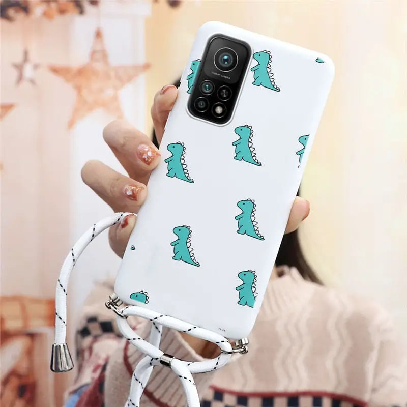 a woman holding a phone case with a green dinosaur pattern