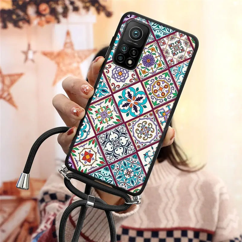 a woman holding a phone case with a colorful pattern