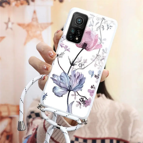 a woman holding a phone case with flowers on it