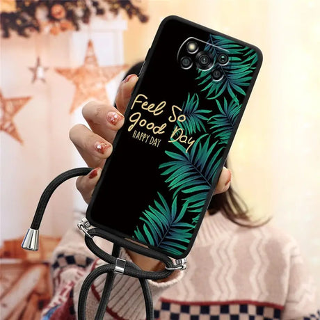 a woman holding a phone case with a tropical leaf design