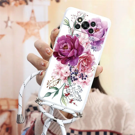 a woman holding a phone case with flowers on it