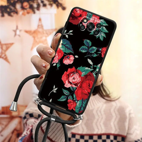 a woman holding a phone case with flowers on it