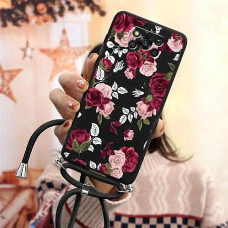 a woman holding a phone case with flowers on it