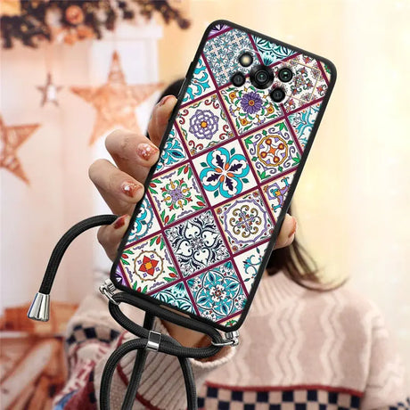 a woman holding a phone case with a colorful pattern