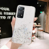 a woman holding a phone case with glitter on it