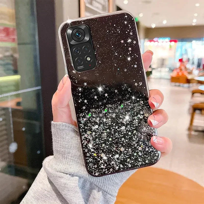 a woman holding up a black and white glitter phone case