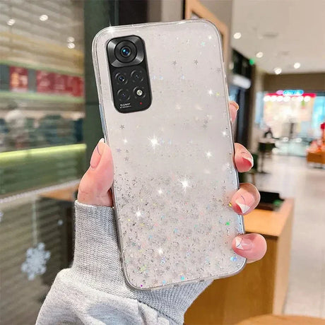 a woman holding up a phone case with glitter