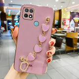 a woman holding a phone case with heart charms