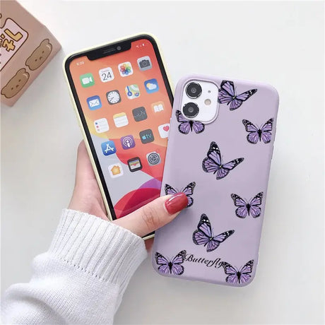 a woman holding a phone case with butterflies on it