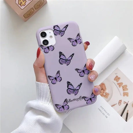 a woman holding a purple phone case with butterflies on it