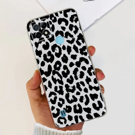 a woman holding a phone case with a black and white leopard print