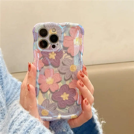 a woman holding a phone case with flowers on it