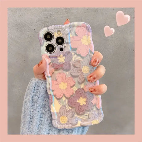 a woman holding a phone case with flowers on it