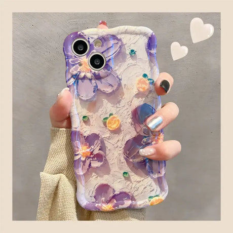 a woman holding a phone case with flowers on it