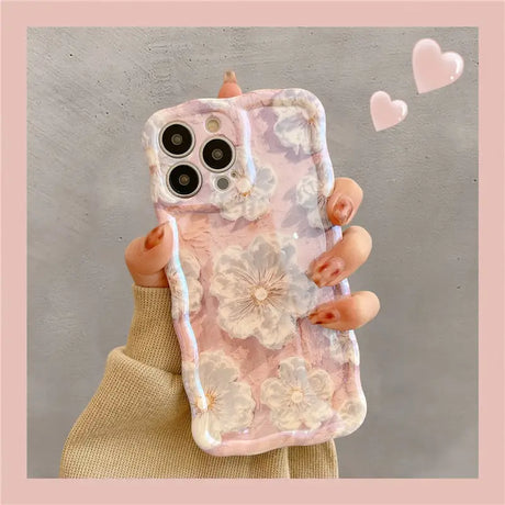 a woman holding a phone case with flowers on it