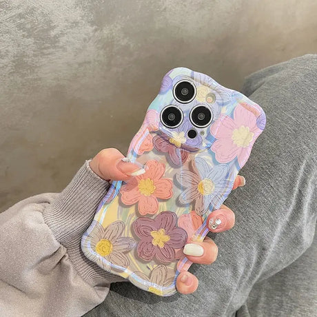 a woman holding a phone case with flowers on it