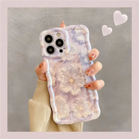 a woman holding a phone case with flowers on it