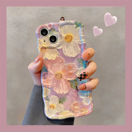 a woman holding a phone case with flowers on it