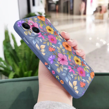 a woman holding a phone case with flowers on it