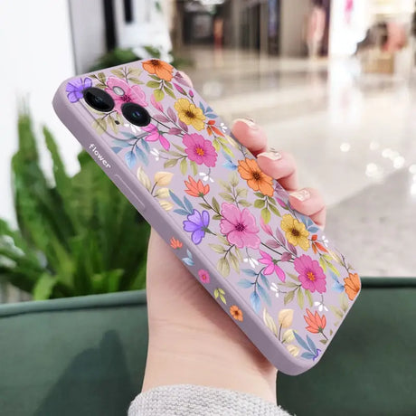 a woman holding a phone case with flowers on it