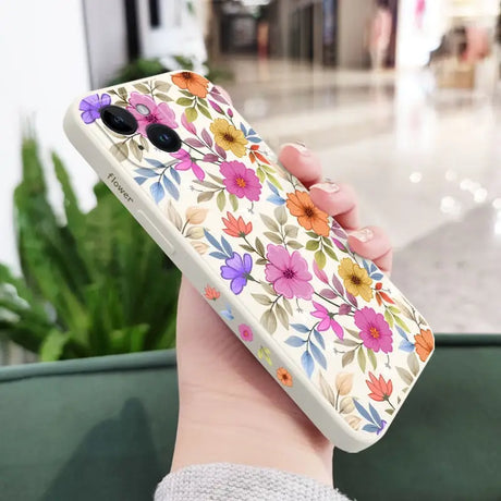 a woman holding a phone case with flowers on it