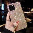 a woman holding up a phone case with a diamond design