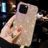 a woman holding up a phone case with a lot of diamonds