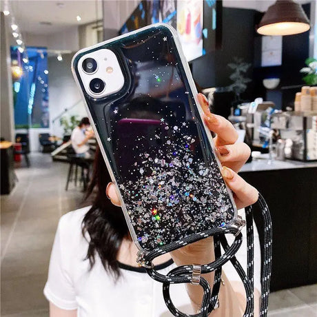 a woman holding up a phone case with glitter