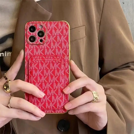 a woman holding a red phone case