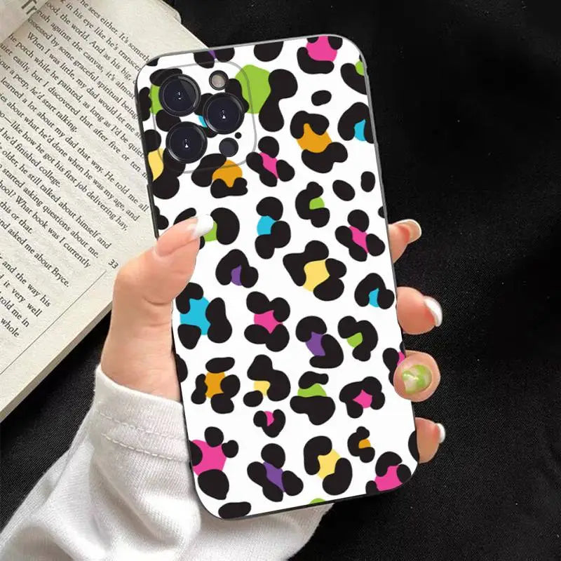 a woman holding a phone case with colorful spots