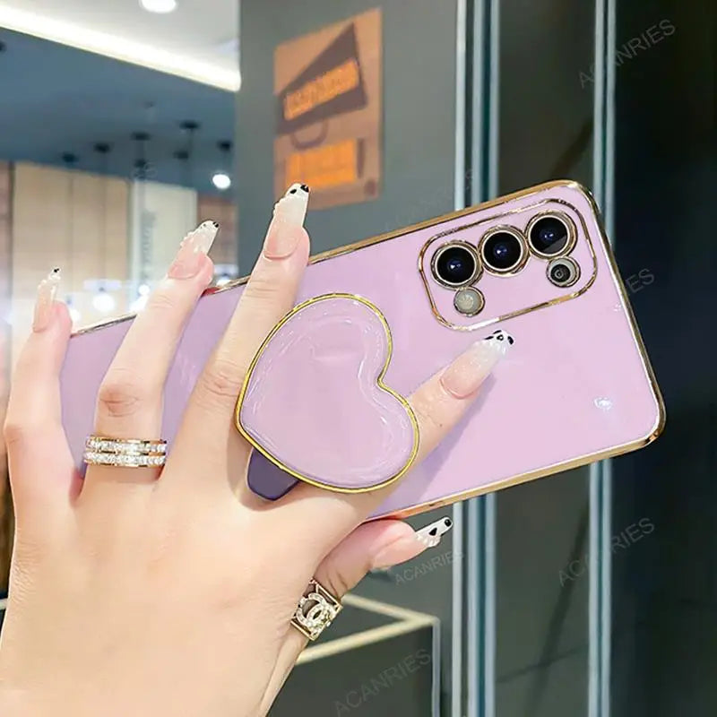 a woman holding a pink phone case with a ring