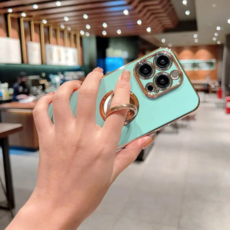 a woman holding a phone with a ring on it