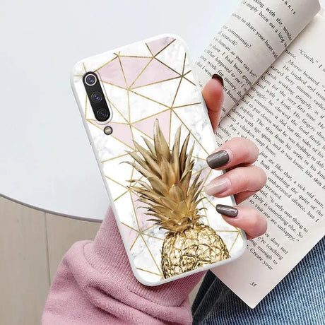 a woman holding a phone case with a pine on it