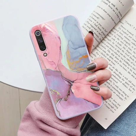 a woman holding a book and a phone case