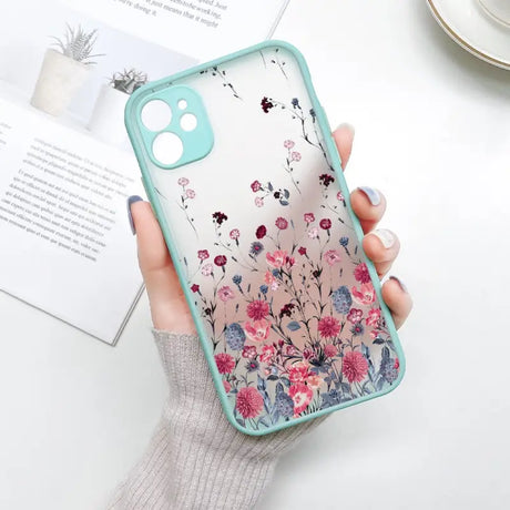 a woman holding a phone case with flowers on it