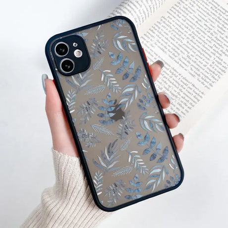 a woman holding a phone case with blue leaves on it