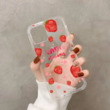 a woman holding a phone case with strawberrys on it