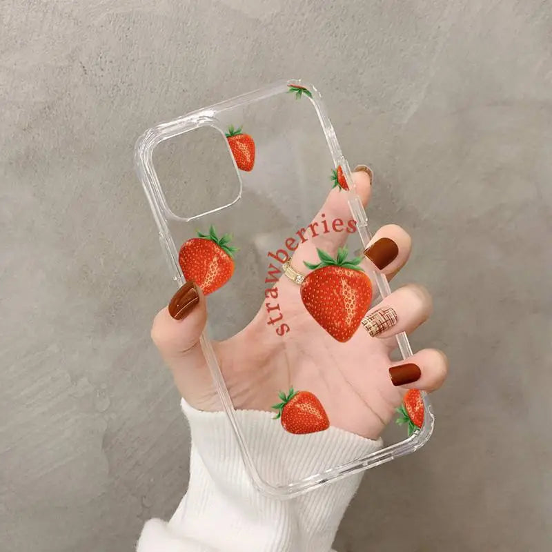 a woman holding a phone case with a strawberry on it
