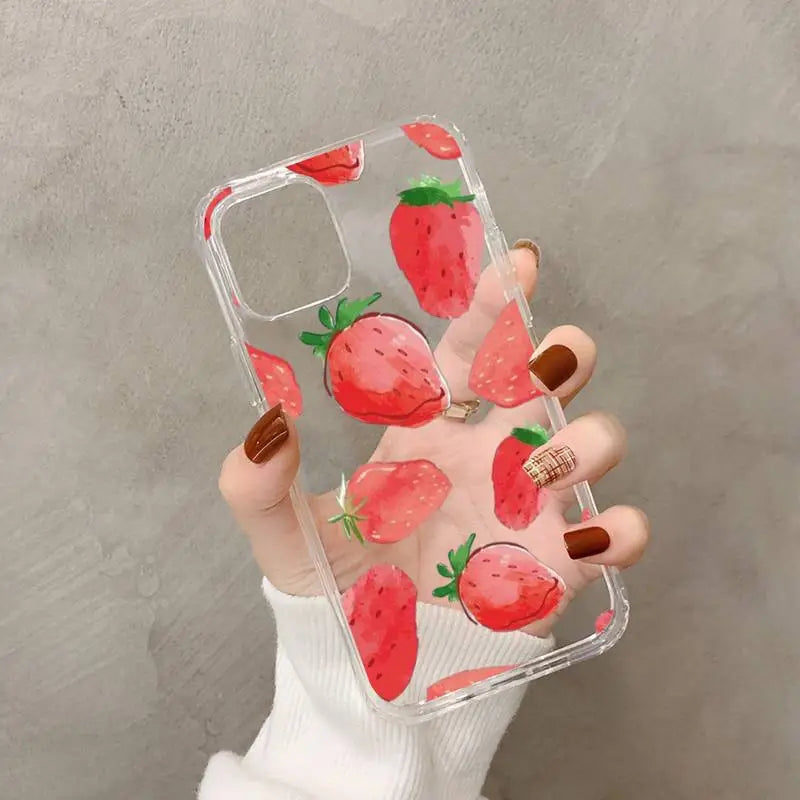 a woman holding a phone case with a strawberry pattern