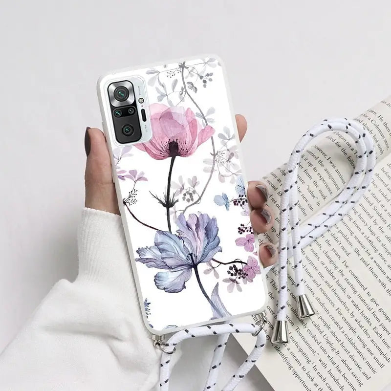 a woman holding a phone case with flowers on it